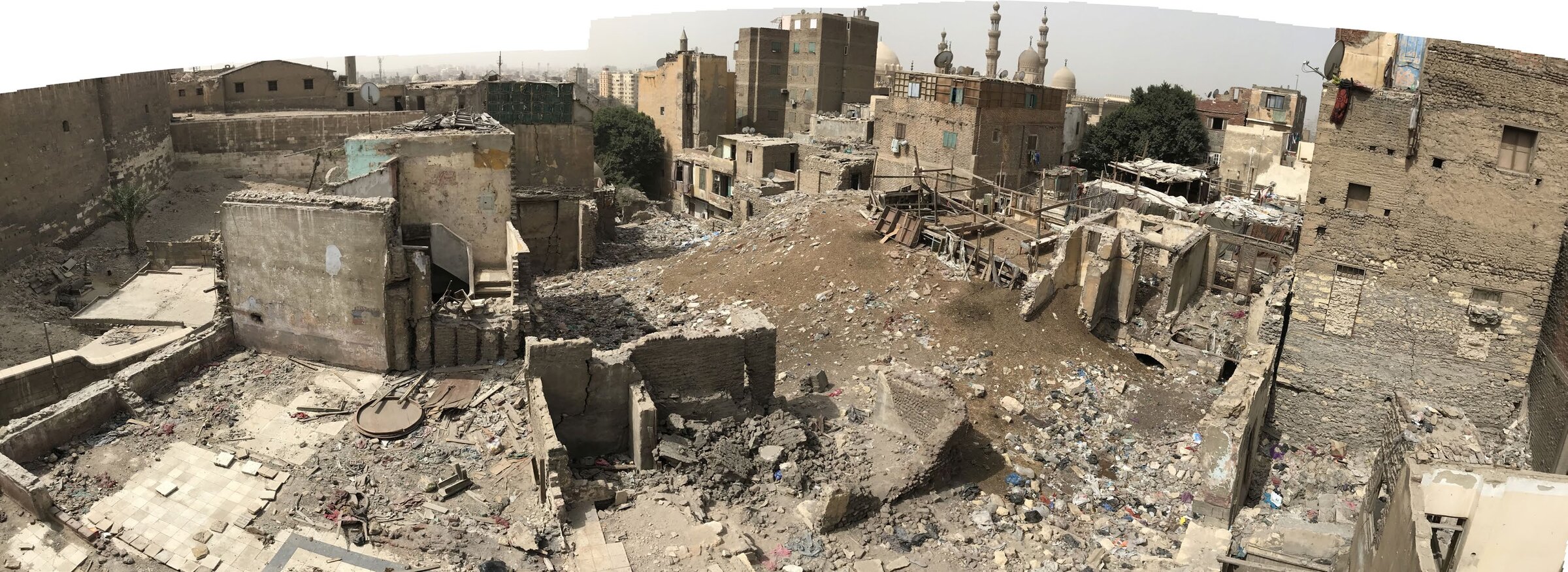 Darb al-Labbana neighbourhood, Historic Cairo — site condition before conservation works, with mosque minarets visible in the distance